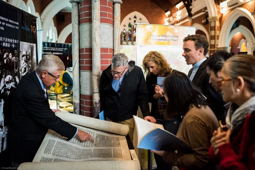 Presenter shows a tour group and open scroll